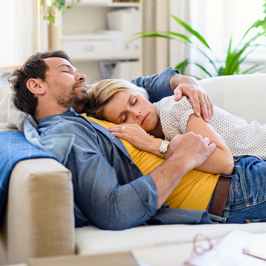 Ein Paar schläft auf der Couch.